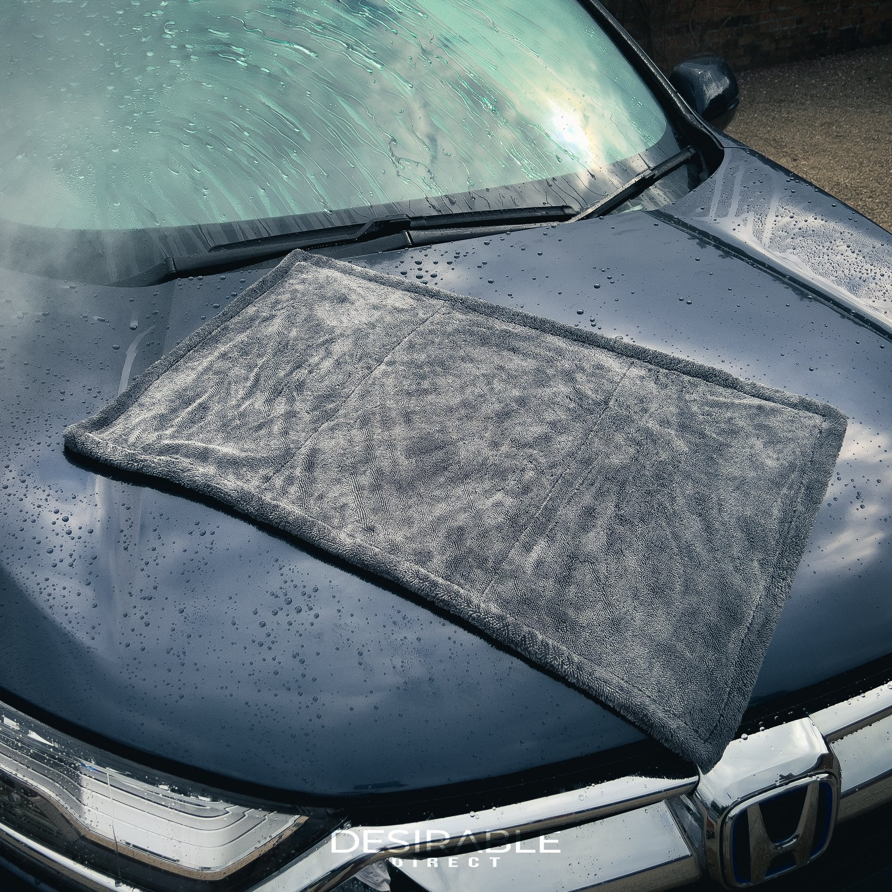 Car care large twisted pile grey drying towel displayed on the bonnet of a grey car. The vehicle is wet to showcase the drying capability of the towel.