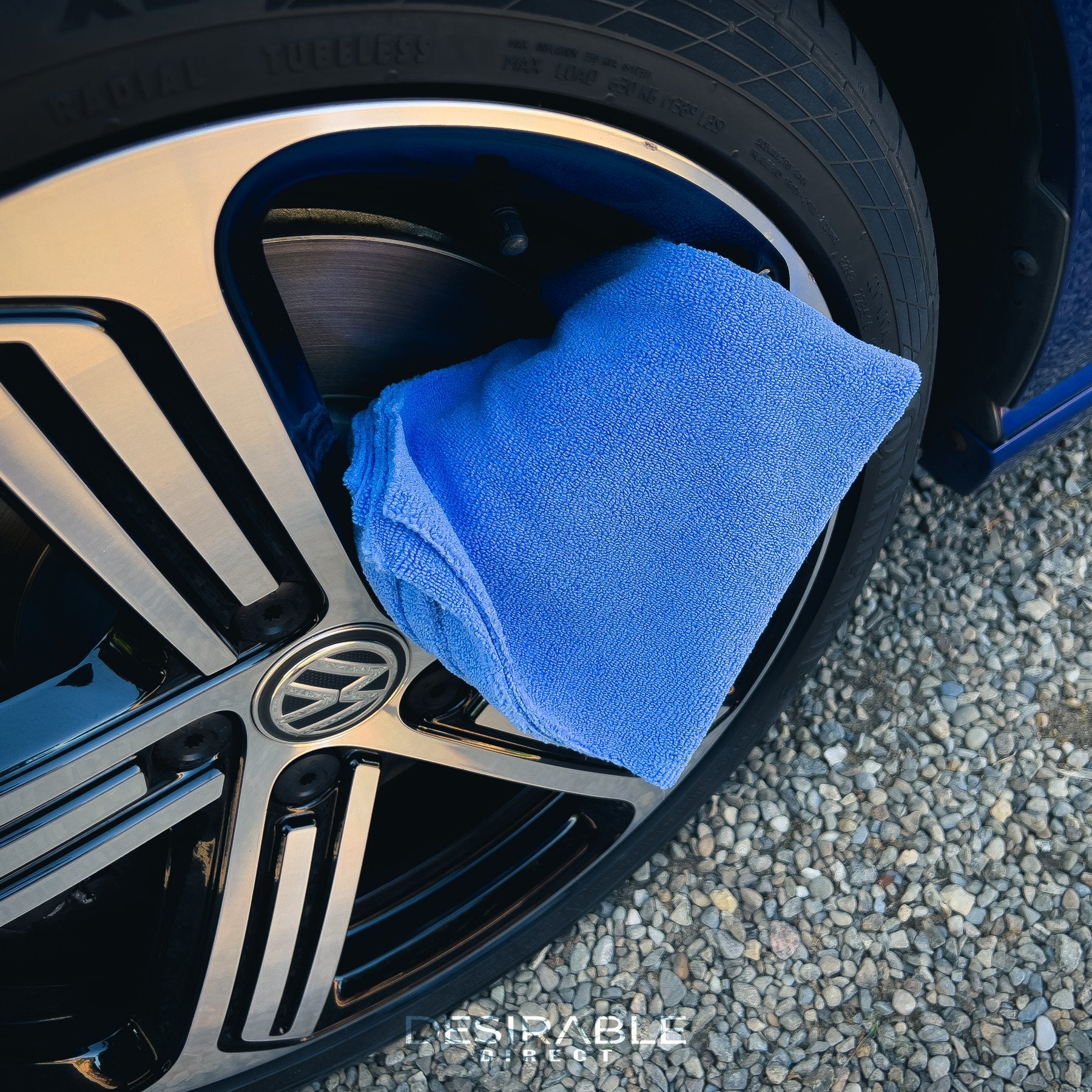 Car care microfibre soft blue multi-purpose cloth 40x40cm hanging on a silver alloy of a blue volkswagen golf r.