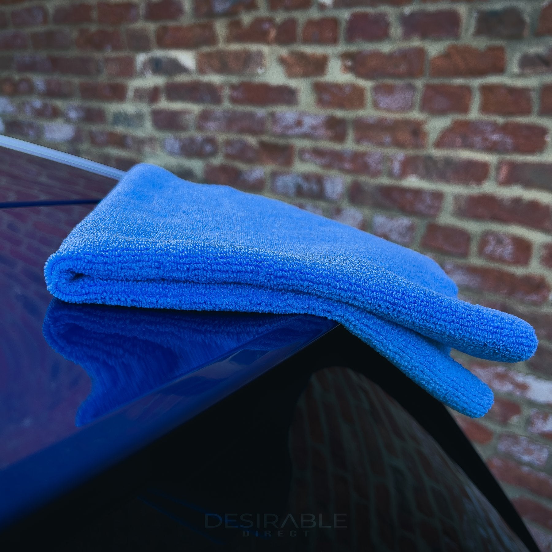 Car care microfibre soft blue multi-purpose cloth 40x40cm on the roof of a blue volkswagen golf r.