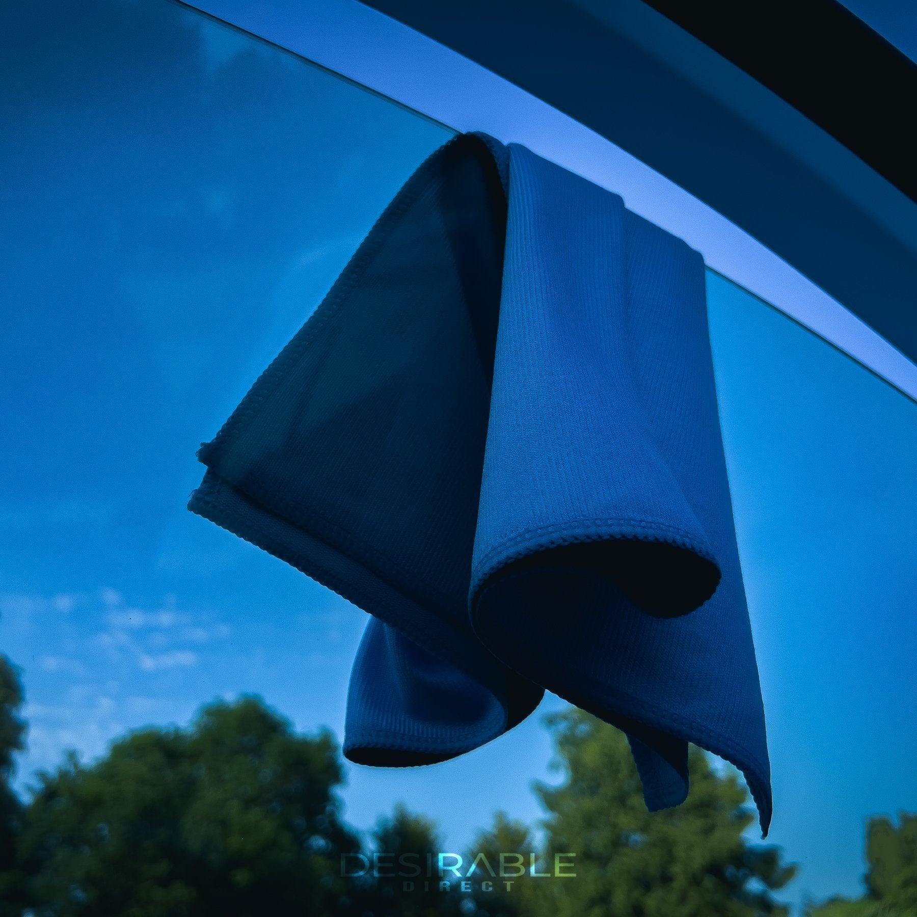 Car care microfibre blue glass cloth 40x40cm hanging from a passenger side window on a blue volkswagen golf r.
