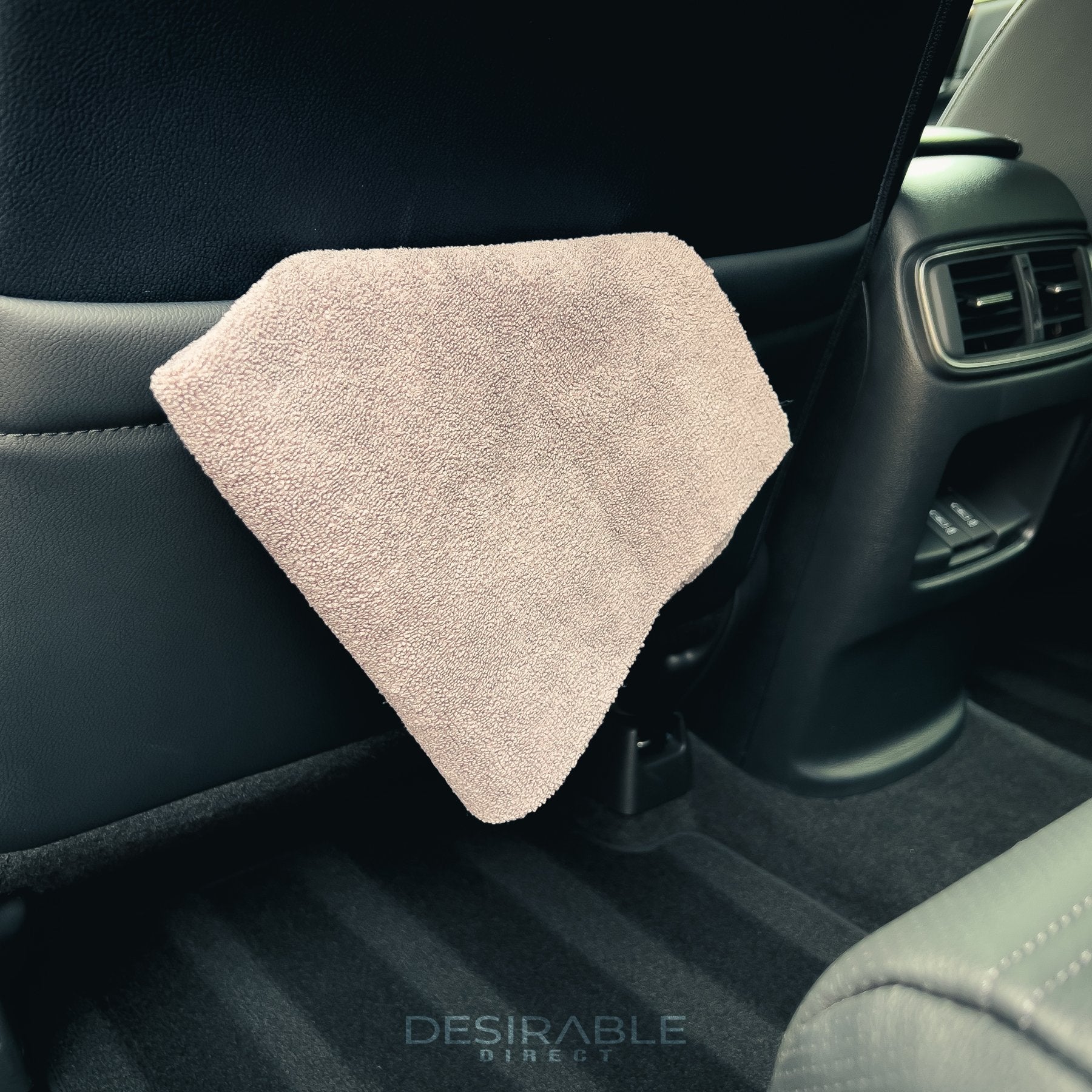 Car care microfibre grey cloth 40x40cm hanging from the rear storage compartment of a cars leather seat.