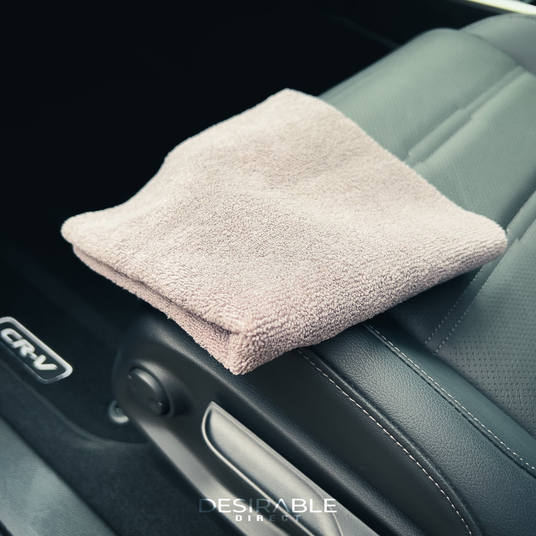 Car care microfibre grey cloth 40x40cm on a passenger leather seat of a grey car.