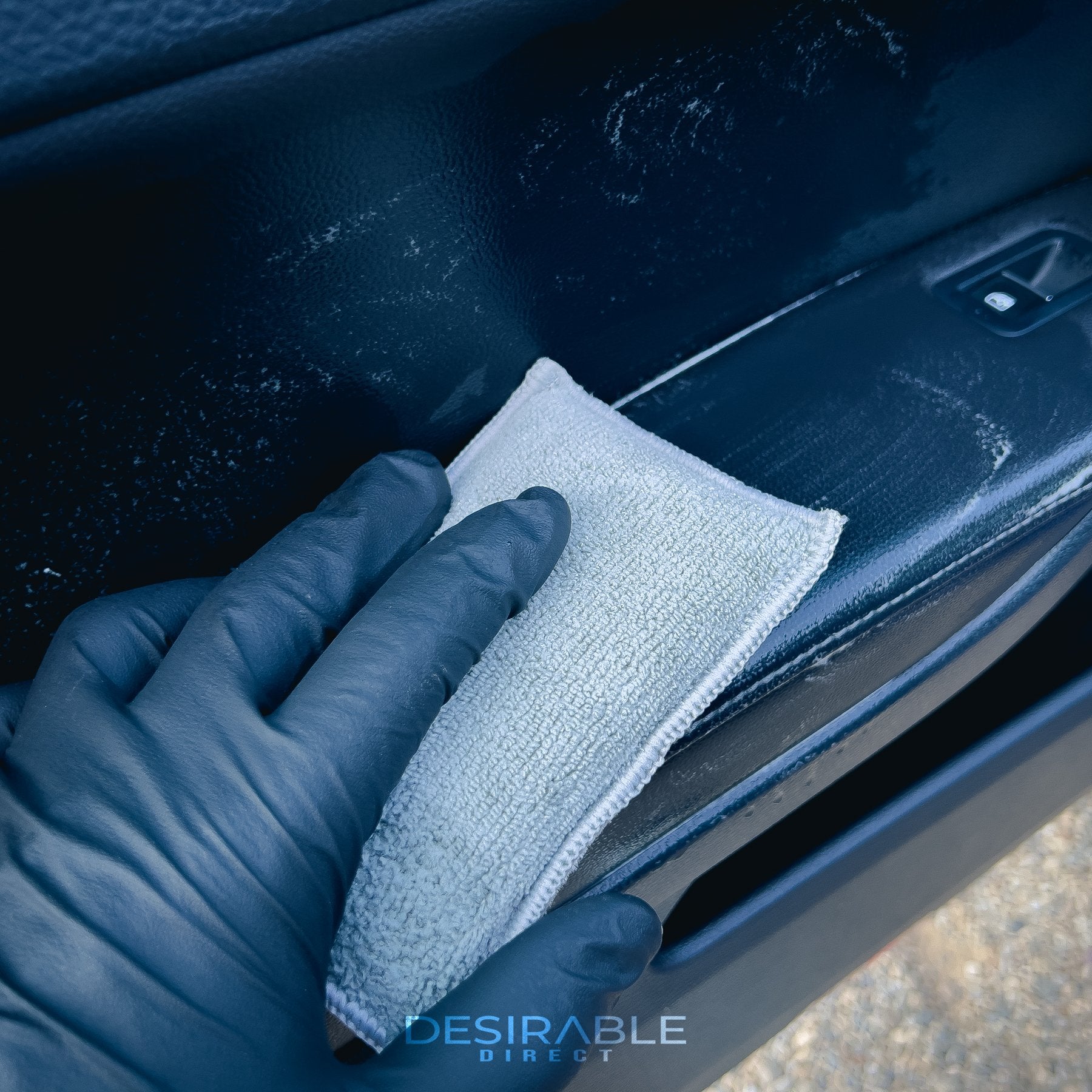 Car care one microfibre grey interior scrub pad cleaning the passenger side door armrest of a blue volkswagen golf r.