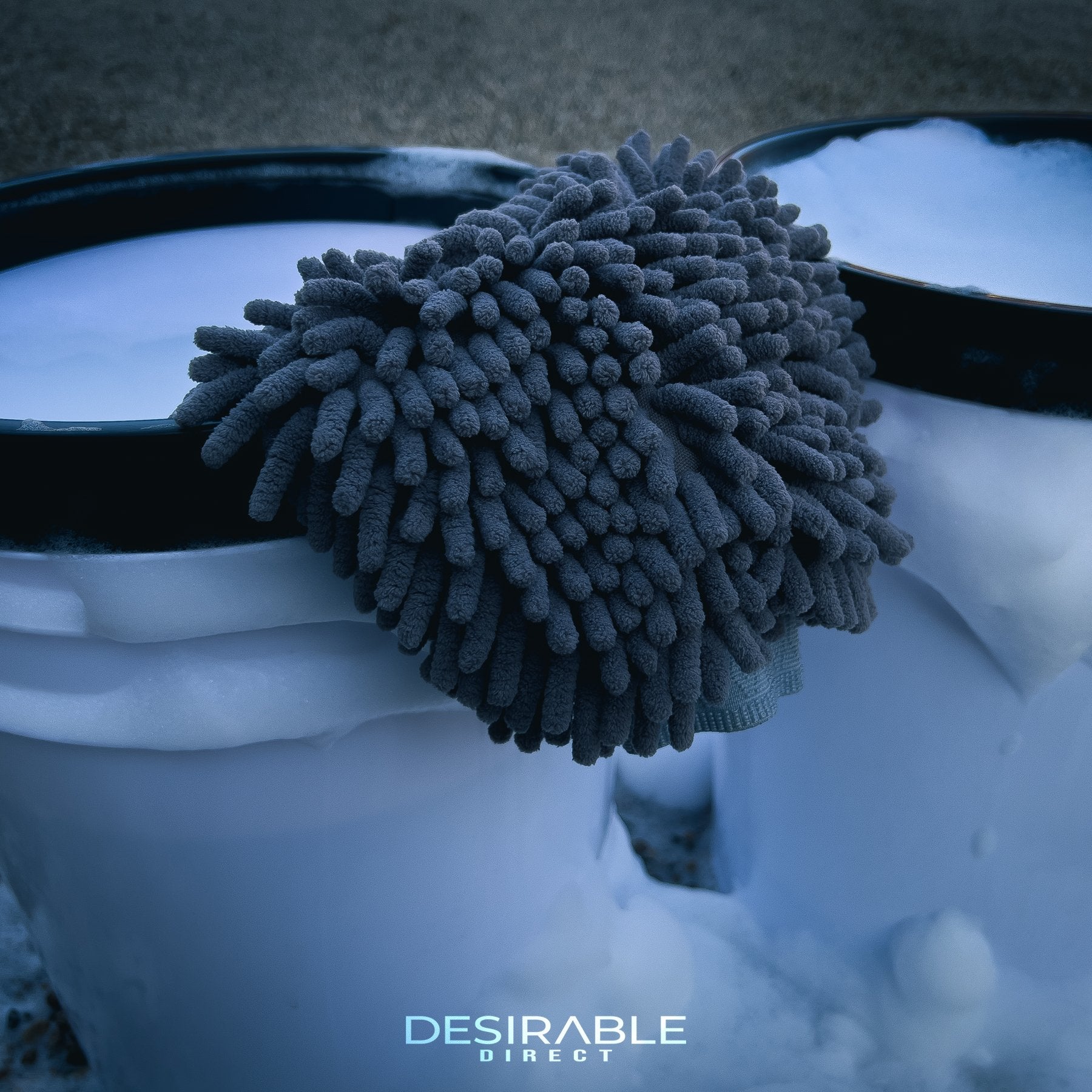 Car care noodle chenille grey wash mitt displayed on the side of a car cleaning wash bucket filled with water and car shampoo.