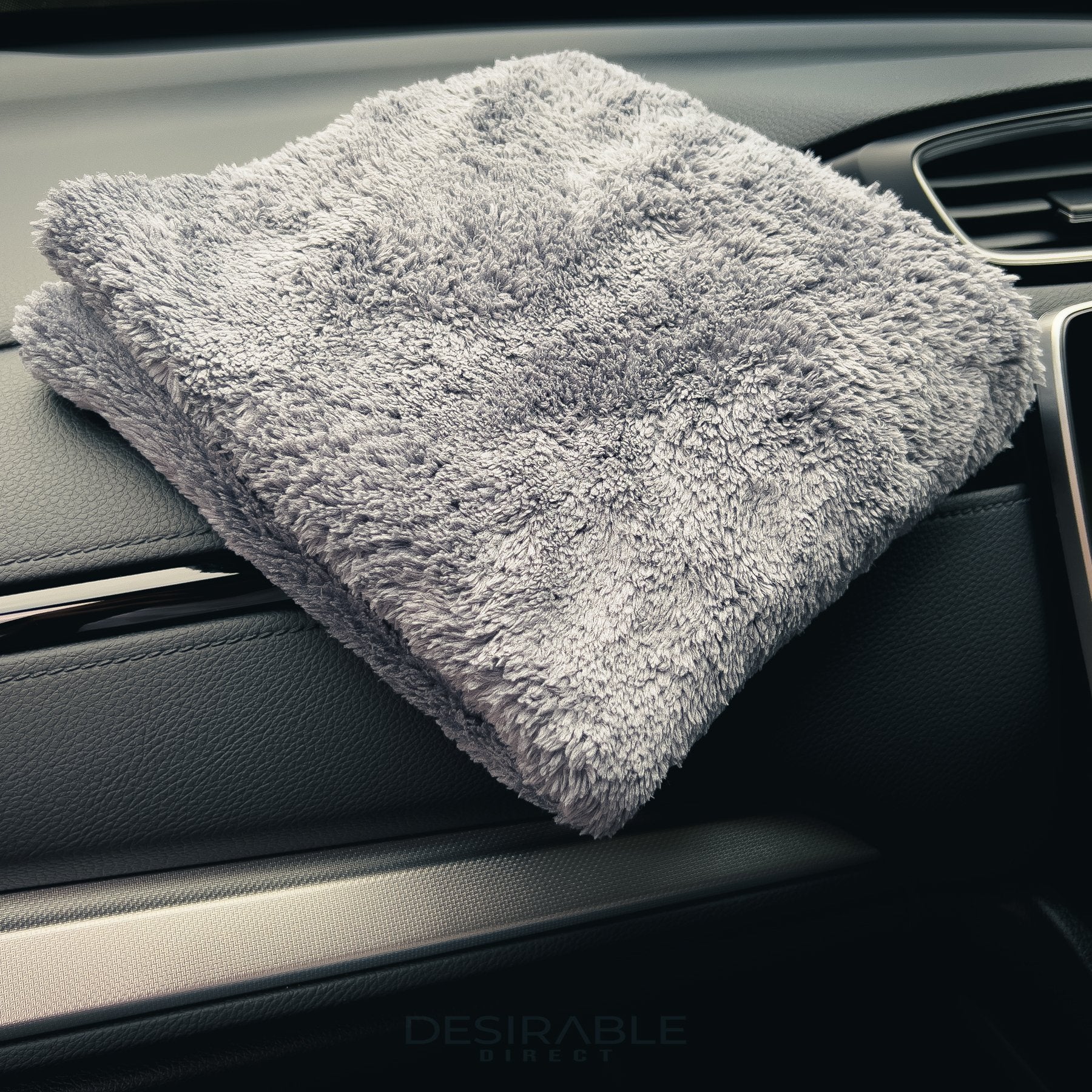 Car care plush grey microfibre cloth displayed on the dashboard of a grey car.