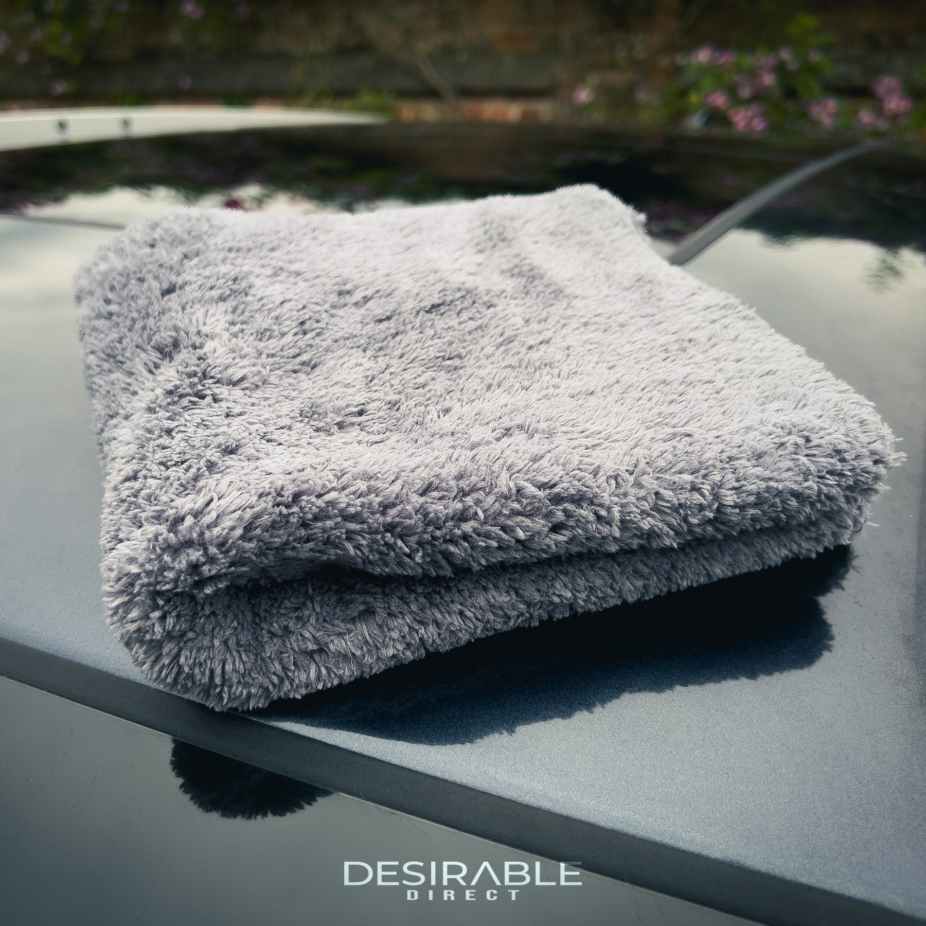 Car care plush grey microfibre cloth displayed on the roof of a grey car.