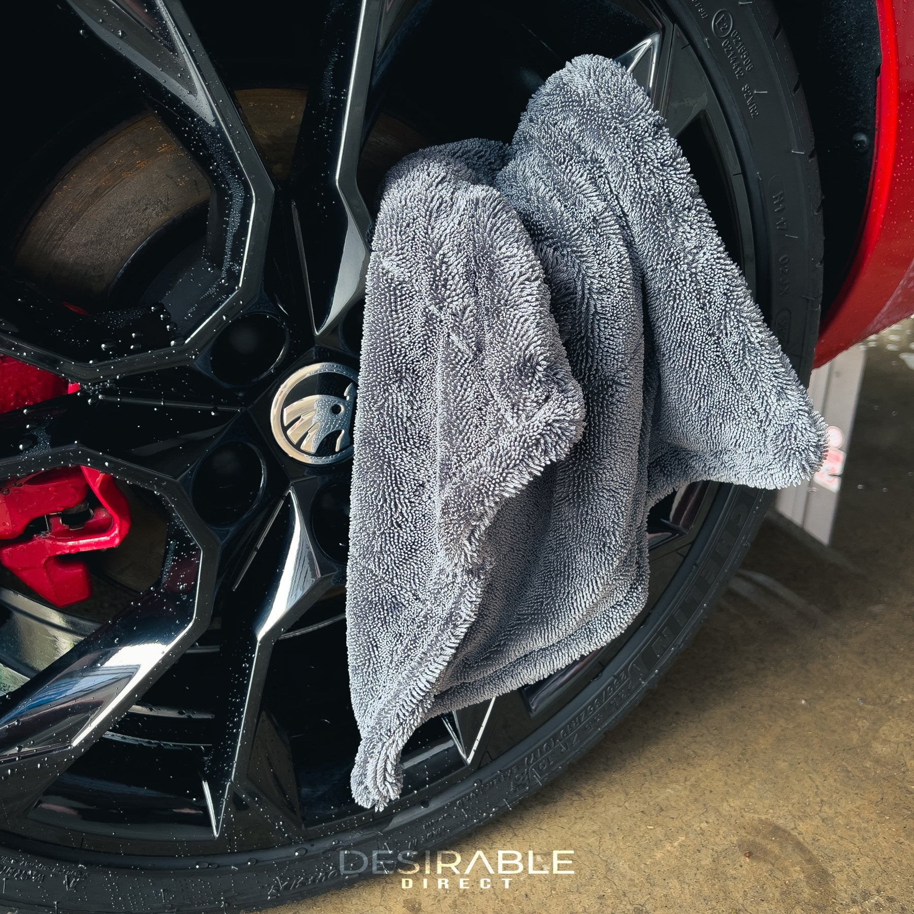 Car care small twisted pile grey microfibre wheel and trim 40x40cm drying towel displayed on a black alloy.