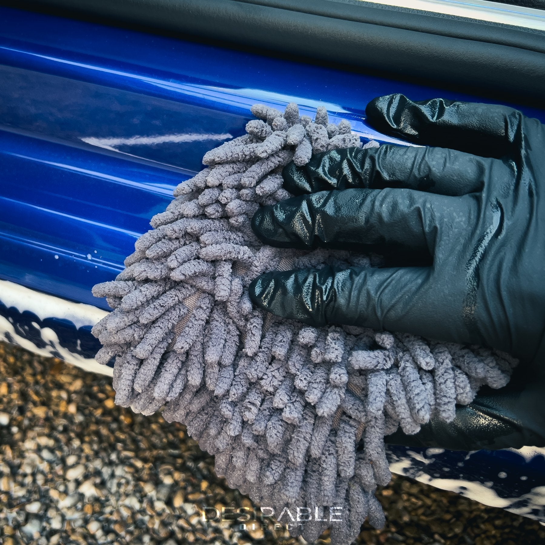 Car care chenille grey wheel and trim noodle wash pad cleaning the passenger side door sill of a blue volkswagen golf r.