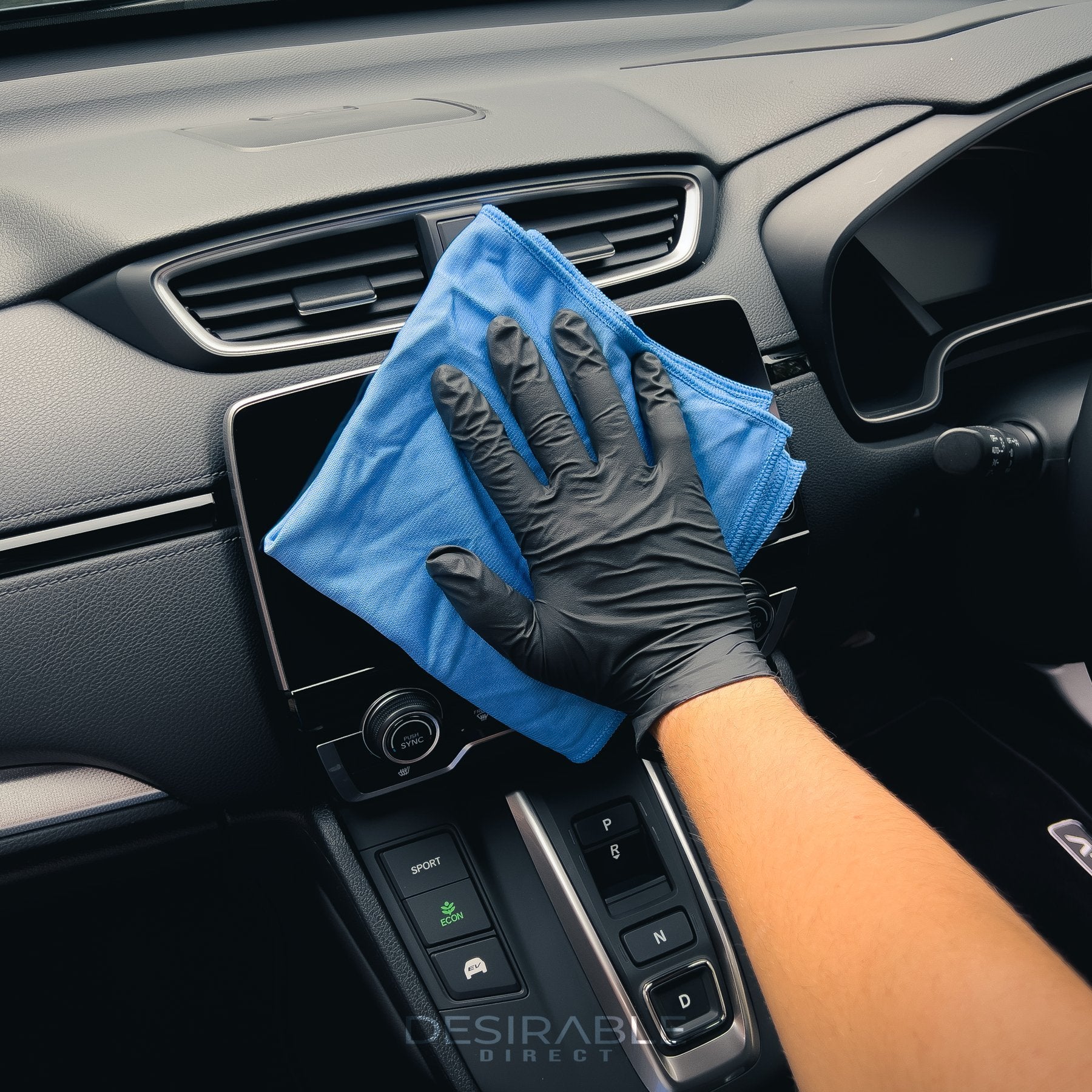 Car care microfibre blue glass cloth cleaning the entertainment screen in a grey car.