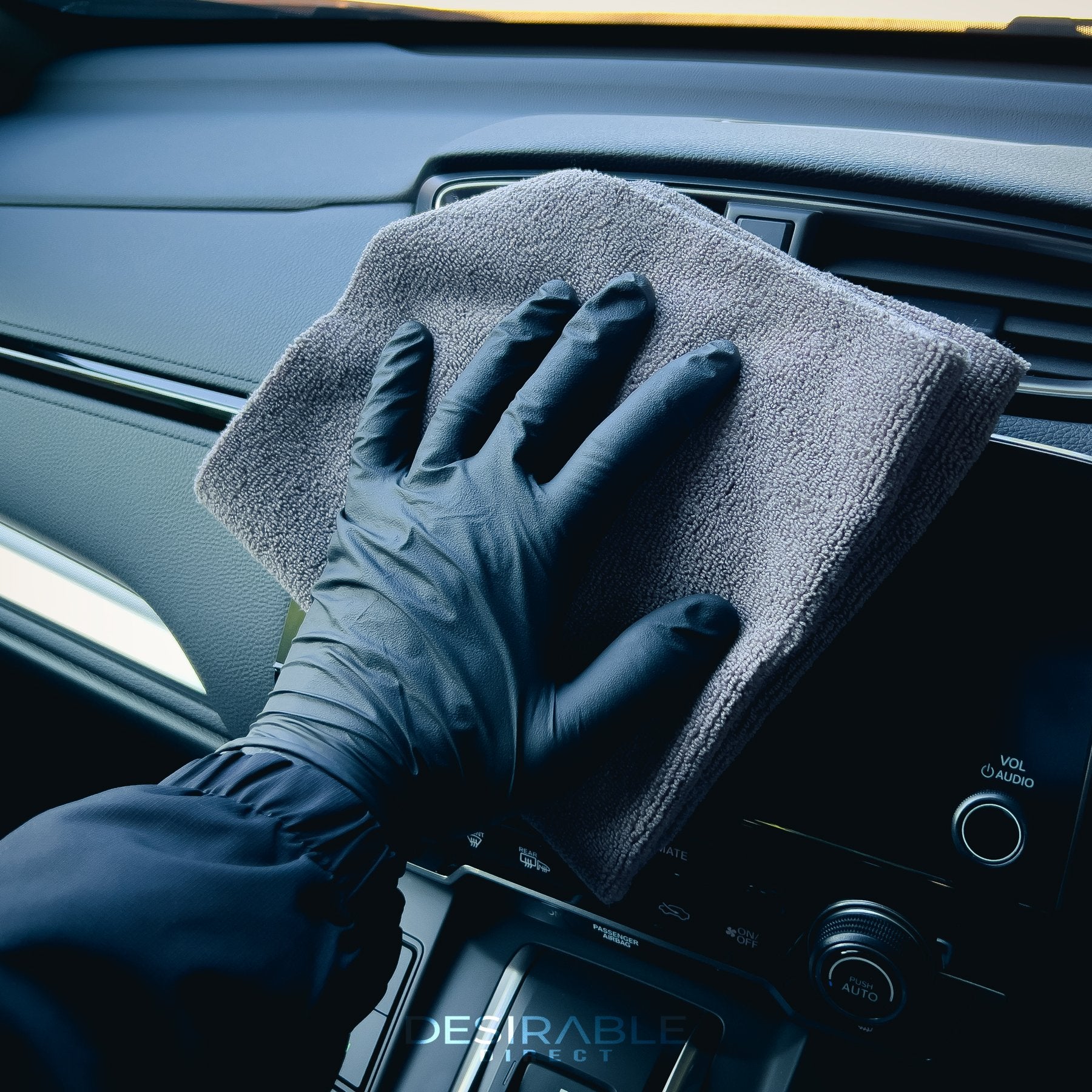 Car care microfibre grey cloth cleaning the entertainment screen in a grey car.
