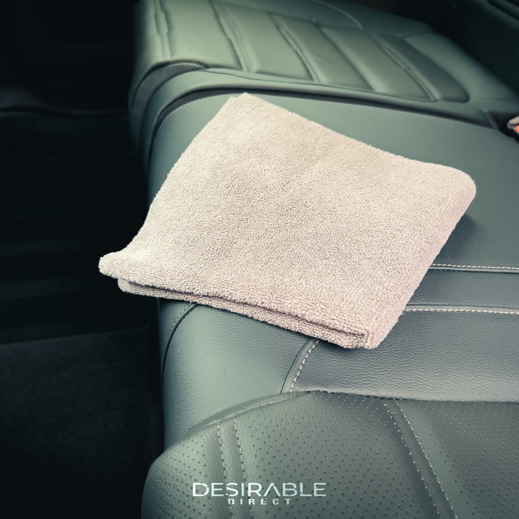 Car care microfibre grey cloth on the rear passenger leather seats in a car.